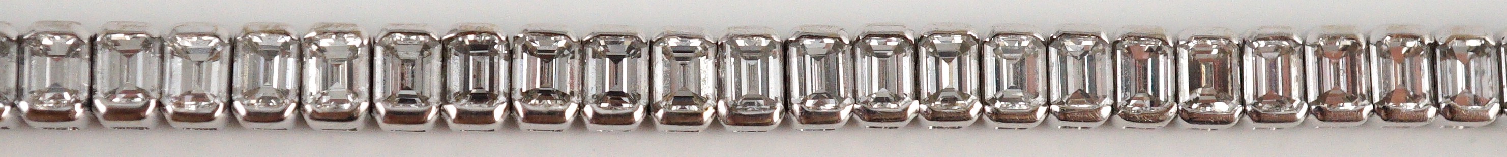 A modern 18ct white gold and emerald cut diamond set line bracelet